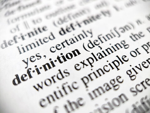 Dictionary definition word defined on paper page with focus blur