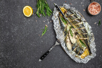 Fried or baked mackerel fish with lemon herbs and spices on a dark background, banner, Food recipe...