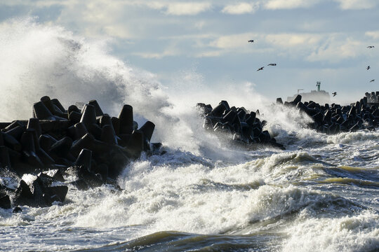 Big waves crash against the harbor breakwater concrete tetrapods during stormy weather
