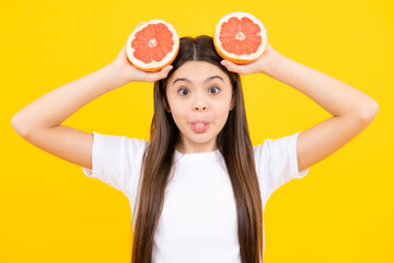 Funny face. Teen girl with grapefruit. Vitamin and fruits. Child eating orange.