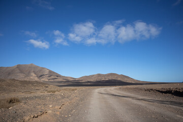 Fototapeta na wymiar Dusty road and mountains, Lanzarote, Spain