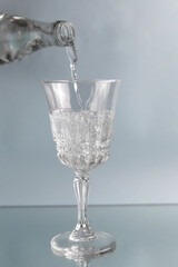 On a blue background, a glass is poured into it with water