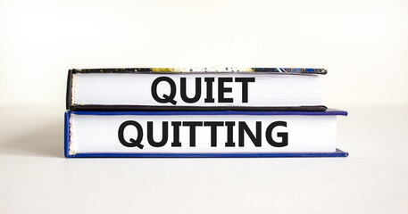 Quiet quitting symbol. Concept words Quiet quitting on books. Beautiful white table white background. Business and quiet quitting concept. Copy space.