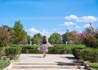 Summer sunny lifestyle fashion portrait of young woman walking in a park