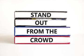 Stand out from the crowd symbol. Concept words Stand out from the crowd on books on a beautiful white table white background. Business, stand out from the crowd concept