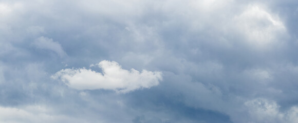 A small white cloud in a dark gloomy stormy sky