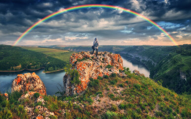 rainbow over the river. woman on a cliff above the canyon. nature of Ukraine
