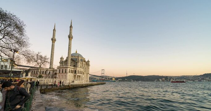 Day to night sunset timelapse scene of the beautiful renovated Ortakoy mosque in Istanbul with Bosphorus bridge in the background.