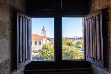 The castle overlooking the medieval town Rhodes, on the island of Rhodes in Greece through the old window. Citadel of the Knights Hospitaller. Clocktower