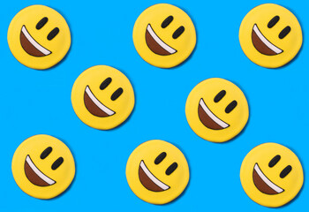 Smileys in the form of gingerbread on the blue background. Flat lay.