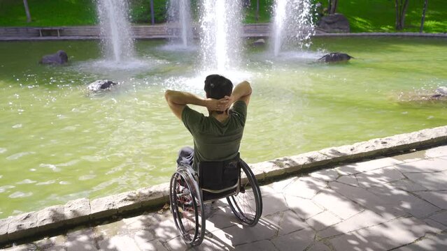 Happy and relaxed young man sitting in his wheelchair.
The physically disabled teenager is happy and quiet outside.
