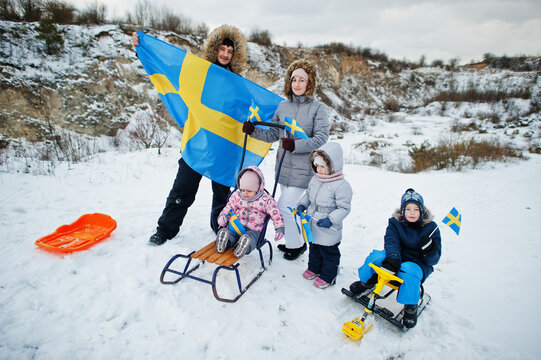 Scandinavian family with Sweden flag in winter swedish landscape.