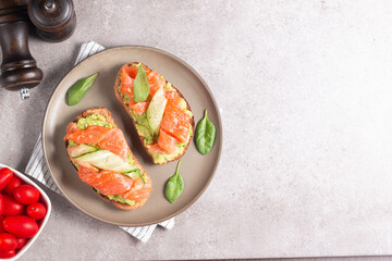 Two tasty open salmon sandwiches with avocado and cucumber. Morning healthy breakfast. Top view.