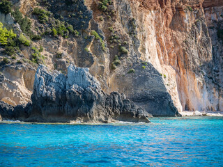 beautiful rocky beach with turquoise water and a big rock