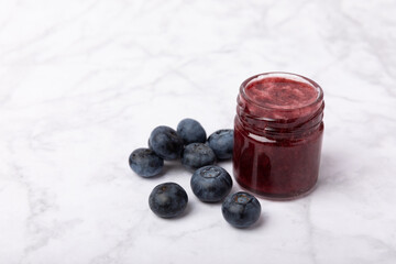 A jar of blueberry honey on a textured background. Cold medicine. Useful fortified jam for health and beauty. Vegetarian diet organic product. Copy space.place for text