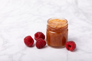 A jar of raspberry honey on a textured background. Cold medicine. Useful fortified jam for health and beauty. Vegetarian diet organic product. Copy space.place for text