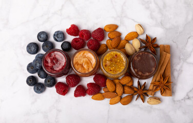 Obraz na płótnie Canvas Jar of honey. Fruit honey with raspberries, blueberries, almonds and pistachios. Jams for health and beauty. Honey cream. Organic product of a vegetarian diet. Copy space.Copy space.