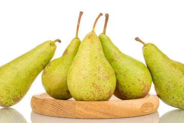 Several juicy organic pears on a wooden dish, close-up, isolated on a white background.