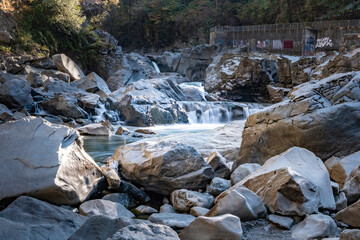 Granite Falls flowing through river boulders and in contrast to the graffiti covered fish ladder © Arnie Lund