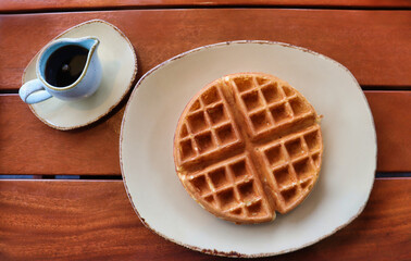 A plain Belgian waffle and warm syrup on the side.