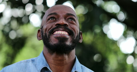 African man taking a deep breath and opening eyes smiling feeling free