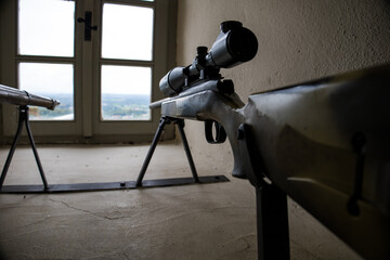 Old weapons in a museum in Austria. Old gun in the museum. New sniper rifle near the window.
