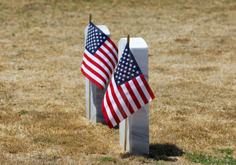 View of two tomb stones with American flags on memorial day.