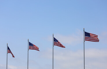 A row of American flags with blue sky copy space.