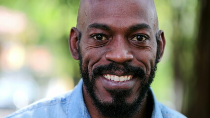 African man smiling standing outside. Black person portrait face close-up