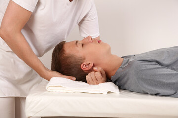 Fototapeta na wymiar Chiropractic adjustment or neck stretch massage for teenage patient. Pain relief concept
