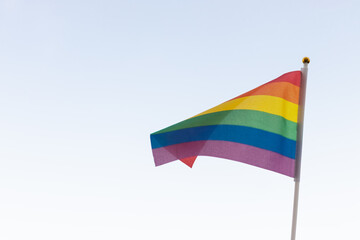 Rainbow flag, a symbol of the LGBT community, waving in the wind on a cloudy background Gay flag