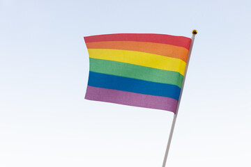 Rainbow flag, a symbol of the LGBT community, waving in the wind on a cloudy background Gay flag