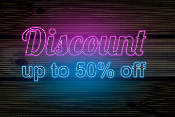 Discount up to 50% off. Neon sign on wooden background. Bright advertising at night