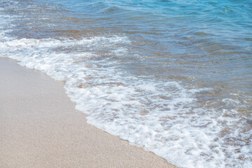 Soft wave of blue sea on sandy beach.