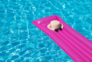 Beach summer holiday background. Inflatable air mattress and hat on swimming pool.;