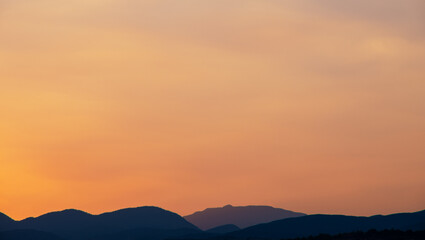 Fototapeta na wymiar Orange sky over silhouette mountain in the morning.