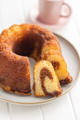 Sweet sponge cake. Bundt cake on plate on white table.