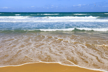 Waves drawing geometric shapes on the shore