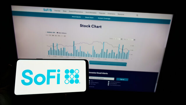 Stuttgart, Germany - 12-12-2021: Person holding mobile phone with logo of US financial company Social Finance Inc. (SoFi) on screen in front of web page. Focus on phone display.