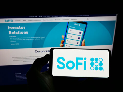 Stuttgart, Germany - 12-12-2021: Person holding smartphone with logo of US financial company Social Finance Inc. (SoFi) on screen in front of website. Focus on phone display.