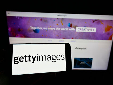 Stuttgart, Germany - 12-12-2021: Person holding cellphone with logo of stock photo provider Getty Images Inc. on screen in front of company webpage. Focus on phone display.