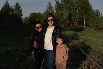 young mother with sons in sunglasses smiling
