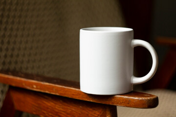 White mug on the armrest of a chair - 532280756