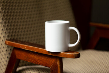 White mug on the armrest of a chair - 532280760