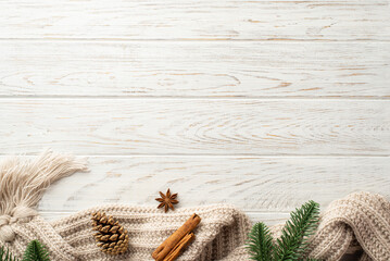 Winter aesthetic concept. Top view photo of pine cone spruce branches cozy knitted plaid anise and cinnamon sticks on white wooden desk background with empty space - Powered by Adobe