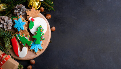 Christmas cookies background. Christmas gingerbread cookies with sugar paste and natural fir tree...