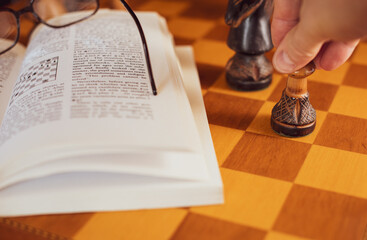 Self studying chess from a book, wooden chessboard and chess pieces