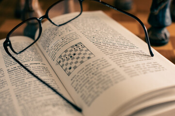 Self studying chess from a book, wooden chessboard and chess pieces