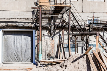 Old destroyed construction site. Rusty scaffolding and construction equipment.