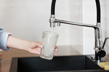 Filling glass of mains water, drinking water close-up. concept of pure drinking water. Water...